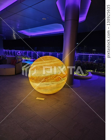 Large yellow and orange ball is lit up and placed on a concrete floor Large yellow and orange ball is lit up and placed on a concrete floor 138925635