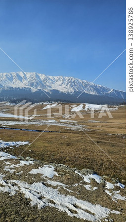 Mountain range is visible in the distance with a snowy peak 138925786