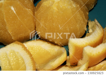 Close up of sliced peeled oranges on a chopping board prepped for using in a salad Close up of sliced peeled oranges on a chopping board prepped for using in a salad 138925823