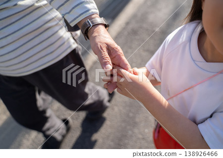 A grandmother and a little girl holding hands A grandmother and a little girl holding hands 138926466