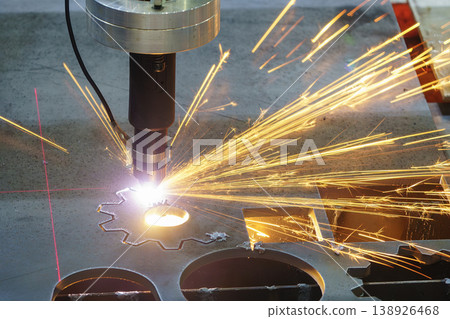 Industrial laser cutting machine processing a high-thickness metal plate with visible laser layout lines. Industrial laser cutting machine processing a high-thickness metal plate with visible laser layout lines. 138926468