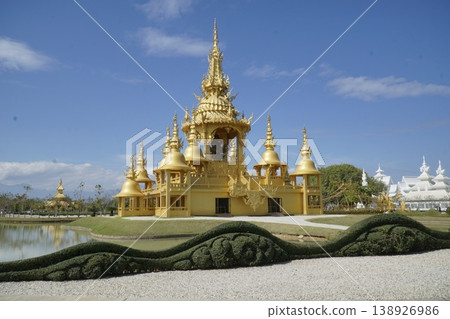 Large gold building with a white roof and a blue sky in the background Large gold building with a white roof and a blue sky in the background 138926986
