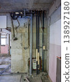 A demolition site in a skeletal state, with exposed concrete walls and equipment piping. 138927180