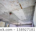 A demolition site in a skeletal state, with exposed concrete ceilings and electrical wiring. 138927181