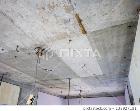 A demolition site in a skeletal state, with exposed concrete ceilings and electrical wiring. A demolition site in a skeletal state, with exposed concrete ceilings and electrical wiring. 138927181