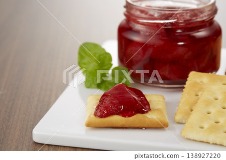 一張看起來色澤誘人、美味可口的草莓果醬和餅乾的圖片。 一張看起來色澤誘人、美味可口的草莓果醬和餅乾的圖片。 138927220