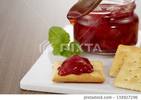 一張看起來色澤誘人、美味可口的草莓果醬和餅乾的圖片。 一張看起來色澤誘人、美味可口的草莓果醬和餅乾的圖片。 138927296