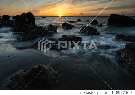 Sunrise and crashing waves 138927360