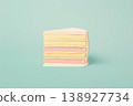 Piece of multi-layered pastel cake on mint background 138927734
