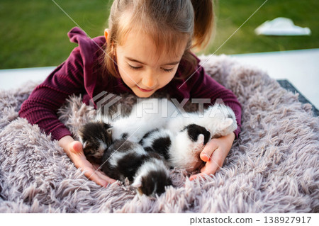 Little girl holding and caring for small kittens outdoors Little girl holding and caring for small kittens outdoors 138927917