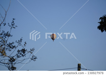 Hot air balloon is floating in the sky above a blue sky 138927978