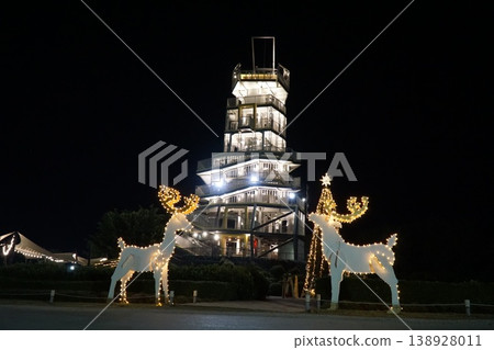 Two large, lit up deer sculptures in front of a tall building Two large, lit up deer sculptures in front of a tall building 138928011