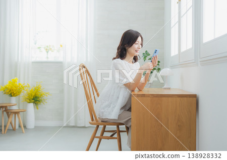 A woman watching a smartphone A woman watching a smartphone 138928332