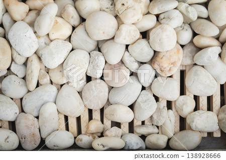 Natural Smooth Stones Arranged in an Aesthetic Pattern on Wooden Slats for Use in Decor, Spa, and Landscape Projects 138928666