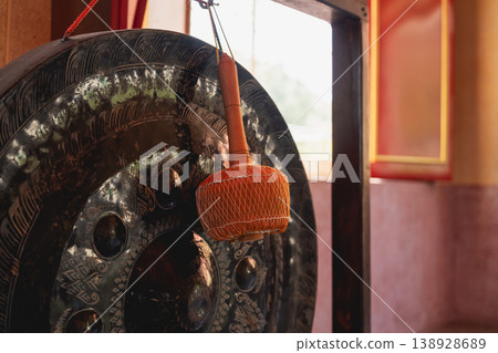Intricate Detail of Traditional Gong Instrument with Wooden Mallet in Cultural Setting, Capturing Serenity and Sound in Artistic Composition Intricate Detail of Traditional Gong Instrument with Wooden Mallet in Cultural Setting, Capturing Serenity and Sound in Artistic Composition 138928689