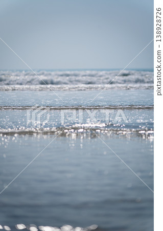Calm Ocean Waves with Glimmering Sunlight Reflections on Water Surface in a Serene Coastal Landscape Calm Ocean Waves with Glimmering Sunlight Reflections on Water Surface in a Serene Coastal Landscape 138928726