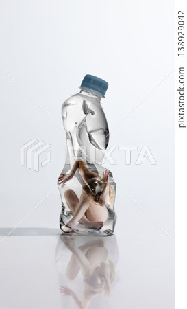 Woman crouched inside plastic bottle symbolizing fear and desire to hide from reality. 138929042