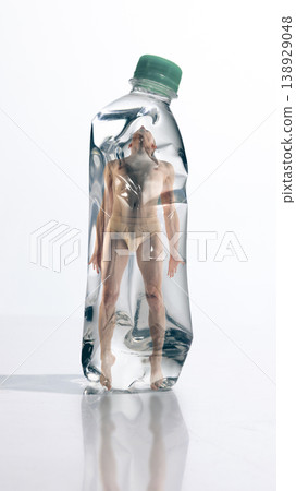 Man enclosed inside plastic bottle representing human dependence and environmental impact. 138929048