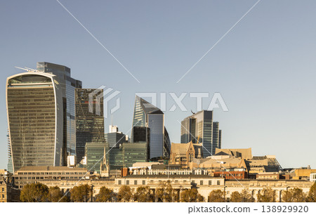 The City of London skyline blends modern glass titans with historic stone anchors. On the left, the flared "Walkie Talkie" stands as a bold contemporary landmark beside the sharp angles of The Scalpel The City of London skyline blends modern glass titans with historic stone anchors. On the left, the flared "Walkie Talkie" stands as a bold contemporary landmark beside the sharp angles of The Scalpel 138929920