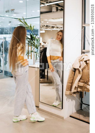 Woman Checking Her Look in Shop Mirror Woman Checking Her Look in Shop Mirror 138930028