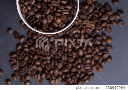 Roasted coffee beans and cup of coffee on granite background Roasted coffee beans and cup of coffee on granite background 138930064