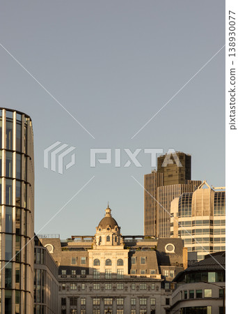 London skyline is a serene dialogue between heritage and ambition, bathed in golden evening light. At its heart, a classical stone building with a stately dome stands with timeless poise. Framing this London skyline is a serene dialogue between heritage and ambition, bathed in golden evening light. At its heart, a classical stone building with a stately dome stands with timeless poise. Framing this 138930077
