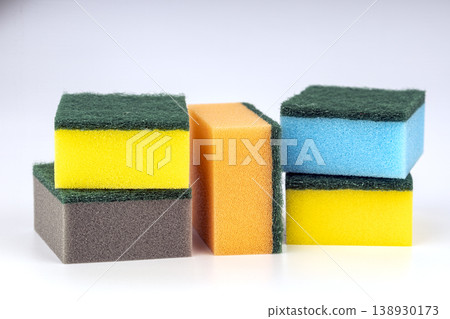 Colorful Kitchen Sponges and Scrubbing Pads Stacked in Rows with Green Abrasive Surfaces Colorful Kitchen Sponges and Scrubbing Pads Stacked in Rows with Green Abrasive Surfaces 138930173