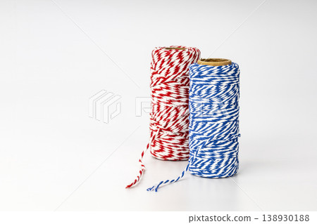 Colorful Red and Blue Striped Twine Spools with Decorative Striped Pattern for Gift Wrapping and Crafts Colorful Red and Blue Striped Twine Spools with Decorative Striped Pattern for Gift Wrapping and Crafts 138930188