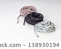 Set of Three Coiled Braided Ropes in White with Blue Stripes, Navy with Red Accents, and Light Pink with Blue Speckles 138930194