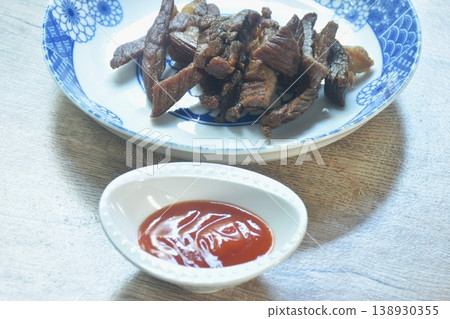 fried crispy salty fermenting beef fat meat with pepper on plate dipping spicy chili sauce fried crispy salty fermenting beef fat meat with pepper on plate dipping spicy chili sauce 138930355