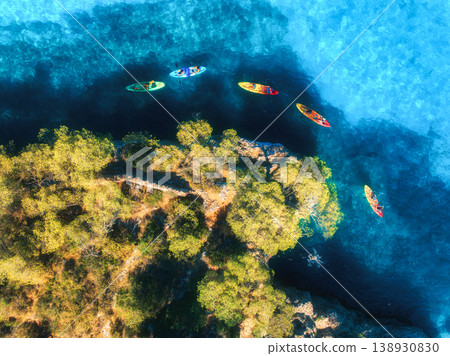 Aerial drone view of colorful kayaks, rocky coastline, blue sea Aerial drone view of colorful kayaks, rocky coastline, blue sea 138930830