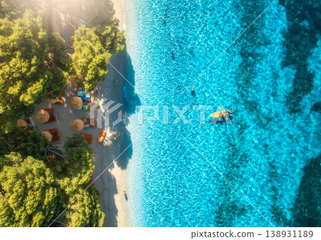 Aerial view of kayak, blue sea, sandy beach, trees and umbrellas 138931189