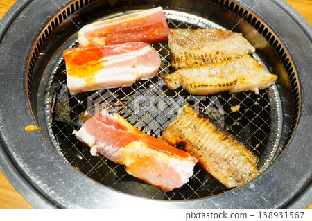 Close-up photo of kalbi and offal being grilled on a yakiniku grill. Close-up photo of kalbi and offal being grilled on a yakiniku grill. 138931567