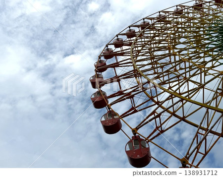 Blue sky, clouds, and a Ferris wheel viewed from below. Blue sky, clouds, and a Ferris wheel viewed from below. 138931712