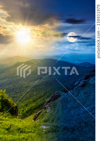 day meet night. mountainous countryside scenery. epic sky above the distant valley at twilight. sun and moon over green meadows and rocks on the hill. wonderful nature scenery of carpathian mountains day meet night. mountainous countryside scenery. epic sky above the distant valley at twilight. sun and moon over green meadows and rocks on the hill. wonderful nature scenery of carpathian mountains 138931979