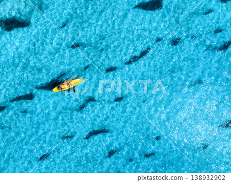 Aerial view of a kayakers paddling through vibrant blue waters 138932902