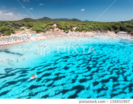 Aerial view of colorful umbrellas on sandy beach, swimming people Aerial view of colorful umbrellas on sandy beach, swimming people 138932907
