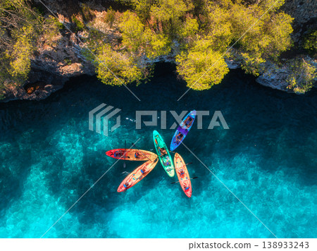 Aerial drone view of colorful kayaks with people on blue sea Aerial drone view of colorful kayaks with people on blue sea 138933243