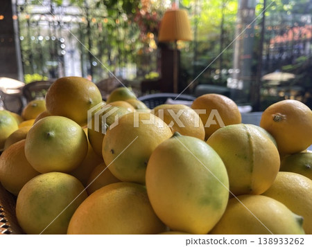 Lemons are placed on a tray in a dining space surrounded by plants. Lemons are placed on a tray in a dining space surrounded by plants. 138933262