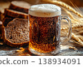 Traditional Cold Kvass in a Glass Mug with Rye Bread and Barley Ears on a Wooden Background 138934091
