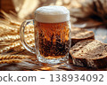 Traditional Cold Kvass in a Glass Mug with Rye Bread and Barley Ears on a Wooden Background 138934092