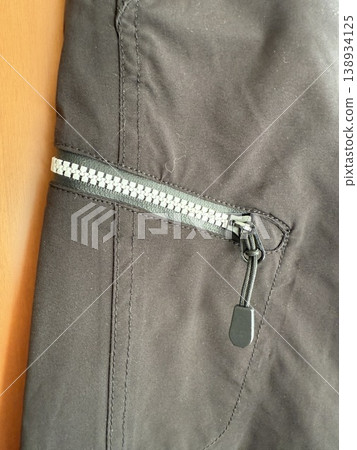 Black jacket zipper detail with visible fabric texture and stitching, suitable for background use Black jacket zipper detail with visible fabric texture and stitching, suitable for background use 138934125