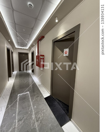 Fire exit door and safety equipment in modern building hallway with marble floor, emergency concept 138934131