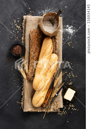 Rustic Baguettes with Flour, Seeds, and Butter on Burlap Rustic Baguettes with Flour, Seeds, and Butter on Burlap 138934145