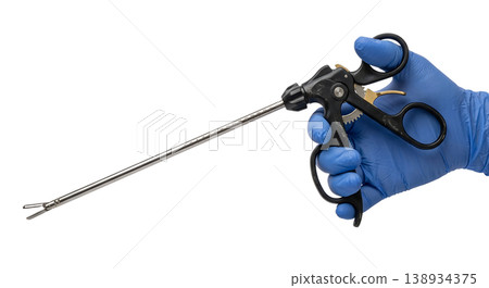 Gloved hand holding a long laparoscopic grasper or forceps with a ratcheted handle and jaw tip, isolated, representing minimally invasive surgery and operating room instruments Gloved hand holding a long laparoscopic grasper or forceps with a ratcheted handle and jaw tip, isolated, representing minimally invasive surgery and operating room instruments 138934375