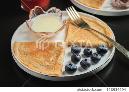 Pancakes with blueberry and honey on a white plate Pancakes with blueberry and honey on a white plate 138934694