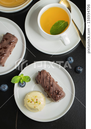 Delicious glazed curd snacks with fresh blueberries and mint on light grey table, closeup Delicious glazed curd snacks with fresh blueberries and mint on light grey table, closeup 138934706