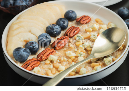 Oatmeal. Bowl of oatmeal porridge with blackberry, bananas and chia seeds on gray concrete old table background. Top view in flat lay style. Natural ingredients. Hot healthy breakfast and diet food Oatmeal. Bowl of oatmeal porridge with blackberry, bananas and chia seeds on gray concrete old table background. Top view in flat lay style. Natural ingredients. Hot healthy breakfast and diet food 138934715