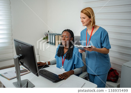 Medical professionals collaborating on computer and digital tablet Medical professionals collaborating on computer and digital tablet 138935499