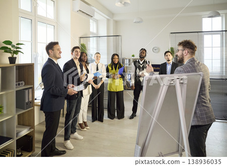 Presenter leading business team meeting with flipchart in bright modern office 138936035